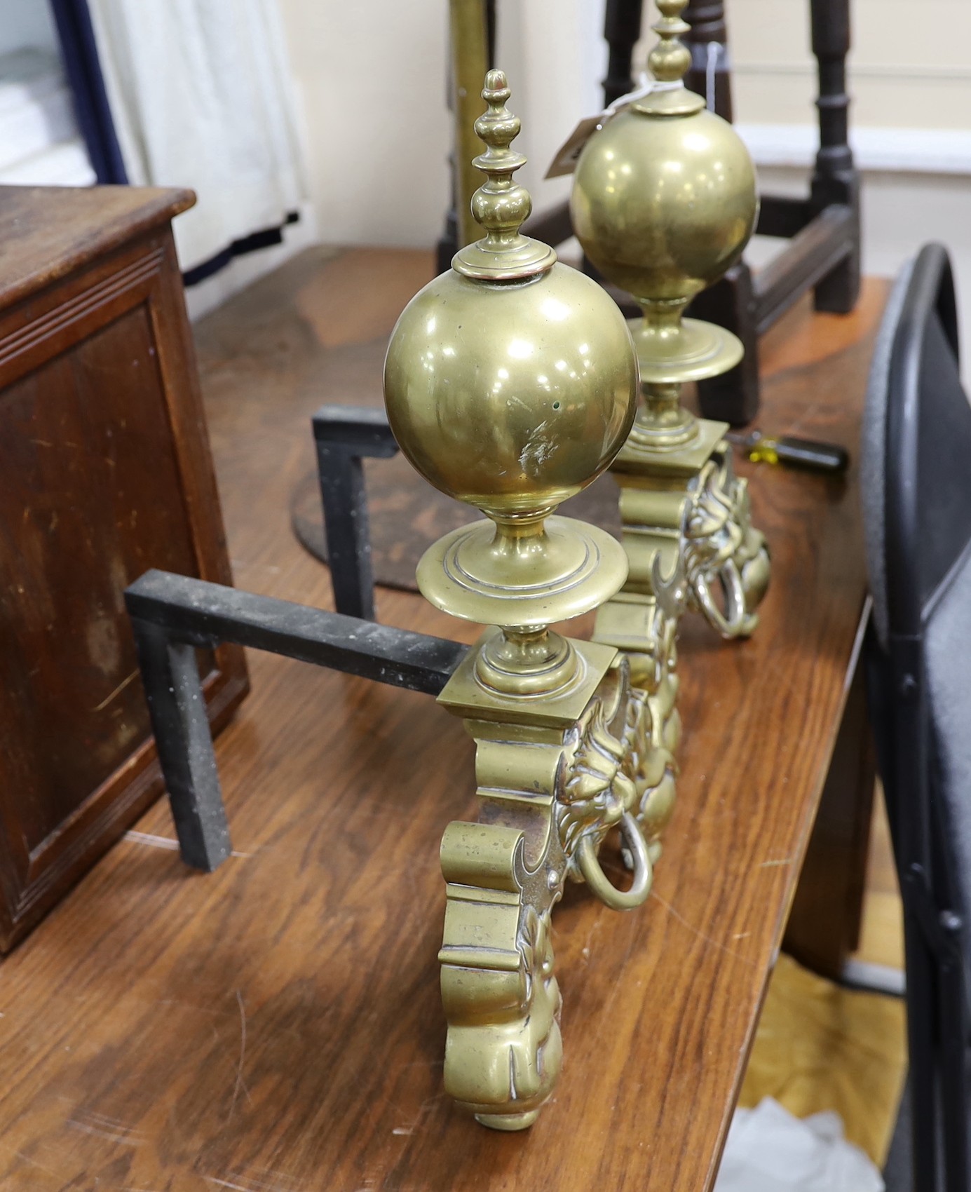 A pair of brass fire dogs